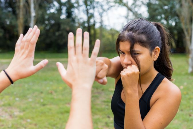 Female boxer training boxing sparring and punching outdoors