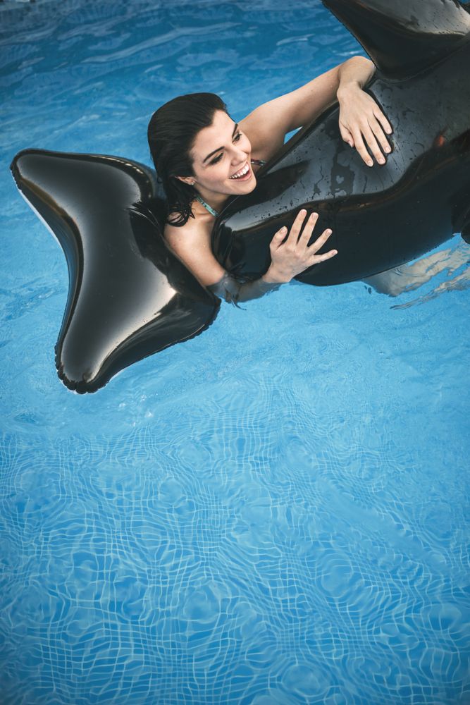 Woman with inflatable toy posing in water