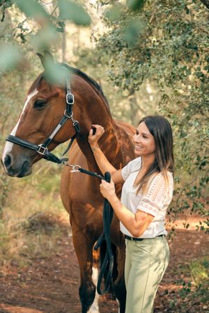 Happy woman with horse in woods