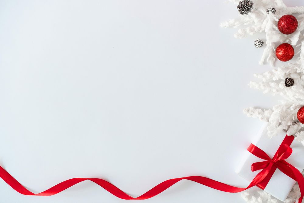 Gift box wrapped with red ribbons, and decorations, on light background