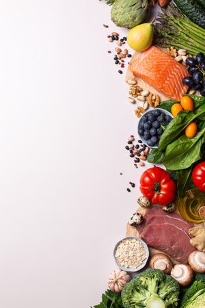 Assortment of healthy food ingredients for cooking lined up on right side of image with copy space