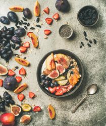 Bowl of yogurt on table with figs, peaches, and chia seeds, square crop