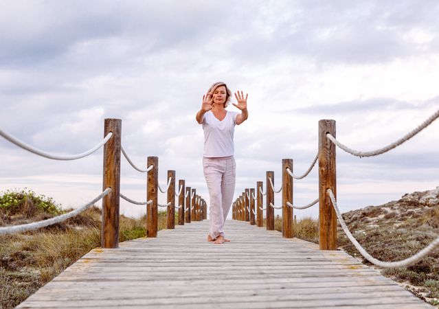 Barefoot woman exercising on wooden path