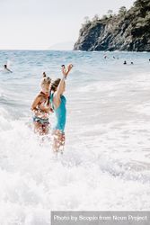 Two girls in swimsuits enjoying the beach 4BxR30