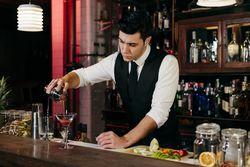 Barman working mixing pouring drink in a glass