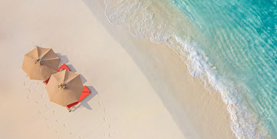 Overhead shot of parasols and reclining chairs on the beach, wide