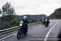 Group of bikers on mountainous highway, riding on curve road pass across Alpine mountains 4MOyk0