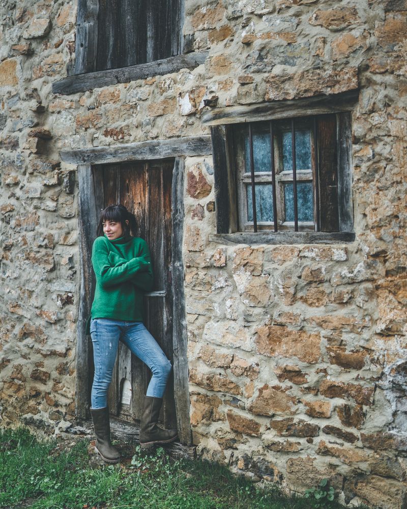 Young woman standing in door of old country house
