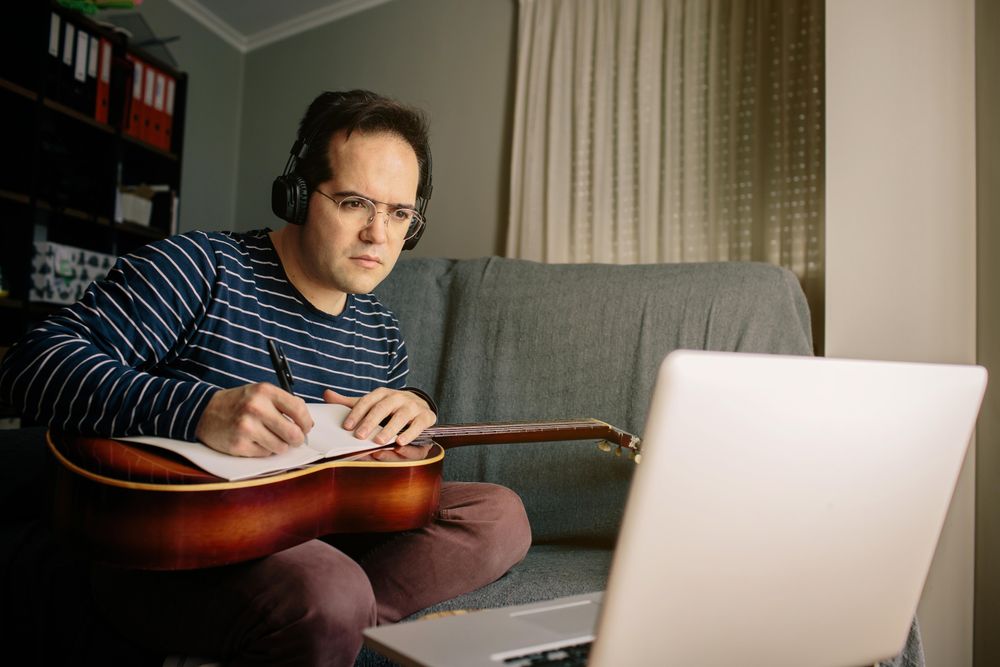 Man learning guitar at home