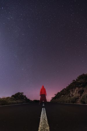 Traveler standing on empty road at night