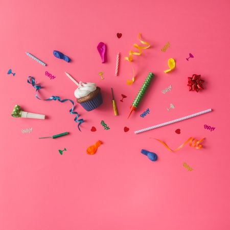 Colorful party items on pink background