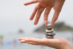 Person adding to pile of small rocks on hands
