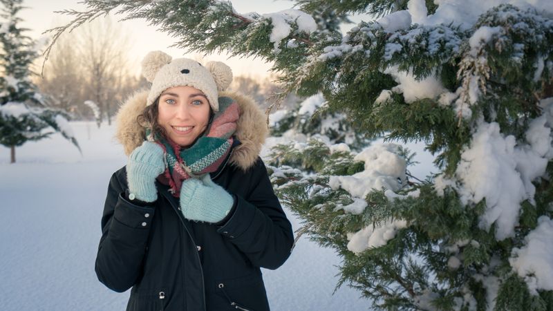 Young woman smiling on snowy background