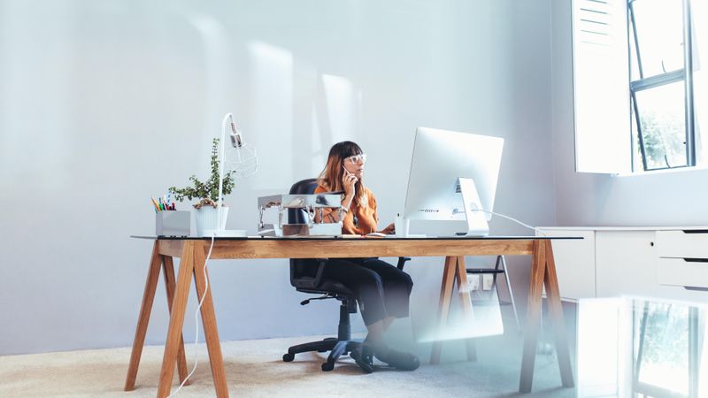 Woman entrepreneur working on computer sitting at office
