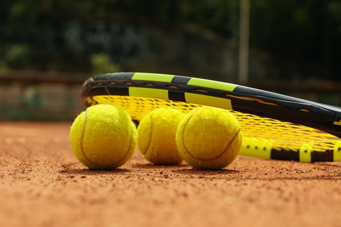 Racket and tennis balls on clay court