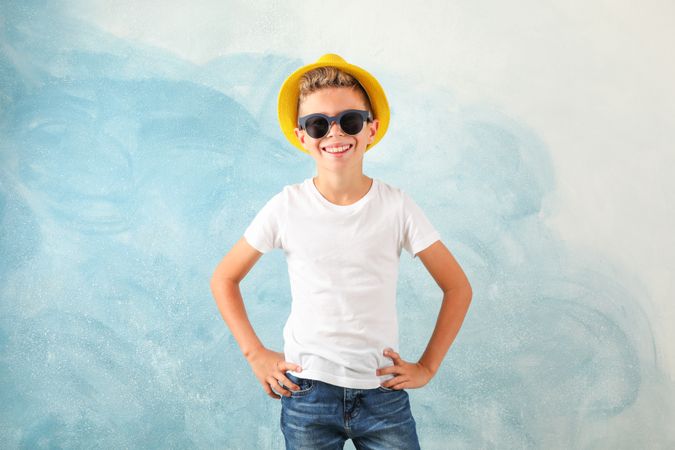 Boy with sunglasses and hat against color background, space for text