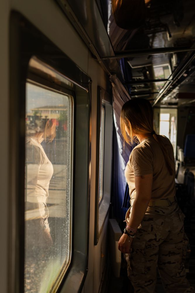 Military woman travelling looking out van window