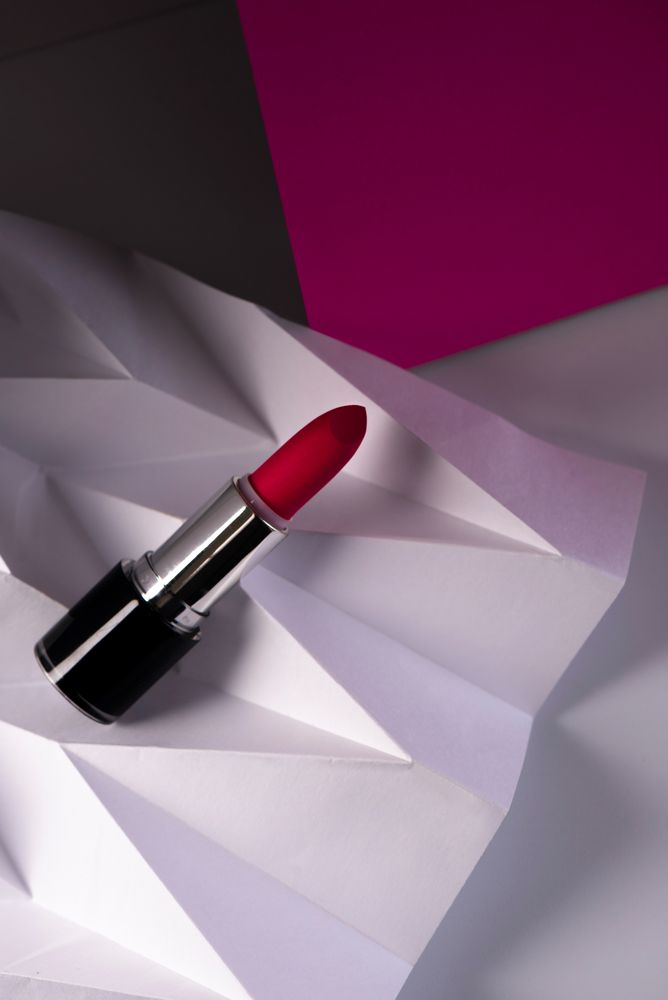 Pink lipstick on raised chevron. Product and make up contemporary concept