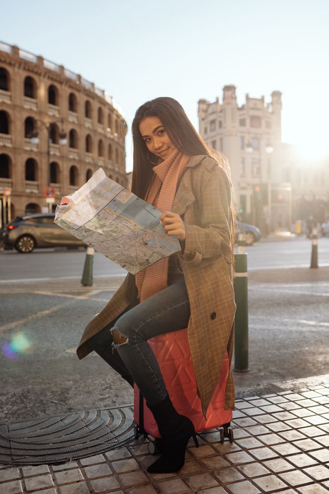 Asian tourist reading map in city
