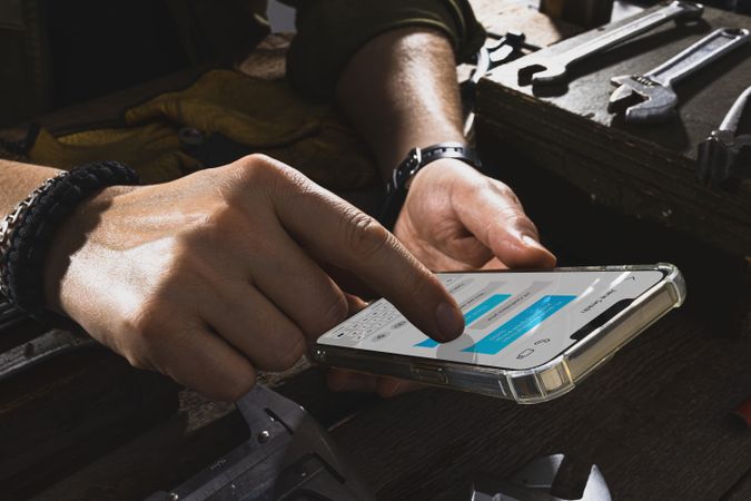 Mechanic with oily hands texting