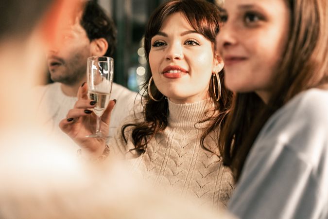 Happy group of diverse friends celebrating Christmas with a champagne toast.