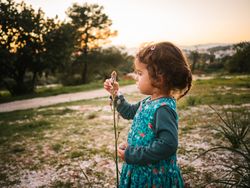 Cute little girl studying flower in park