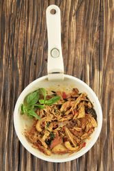 Looking down at skillet of Indonesian shredded chicken dish