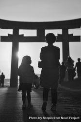 Back view of mother and child standing near Torii in grayscale 0KJdAb