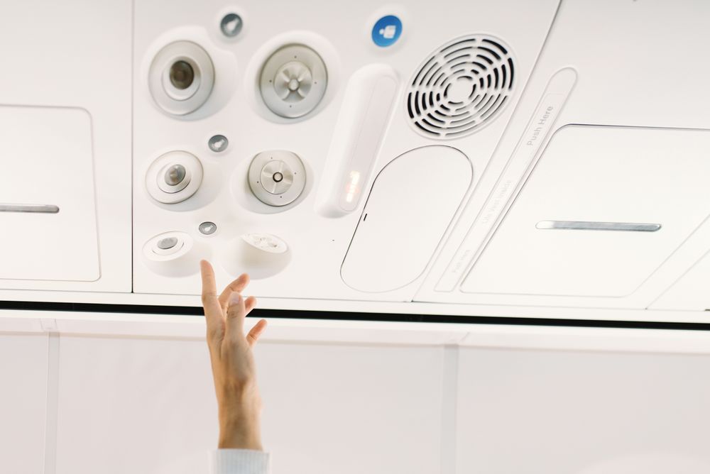 Person pressing button on panel up airplane