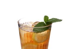 A glass of cold tea with an orange, isolated on plain background