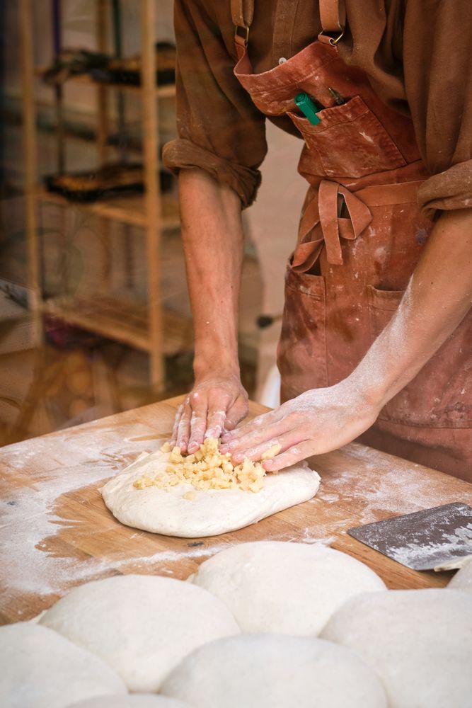 Young male baker preparing dough for bread making