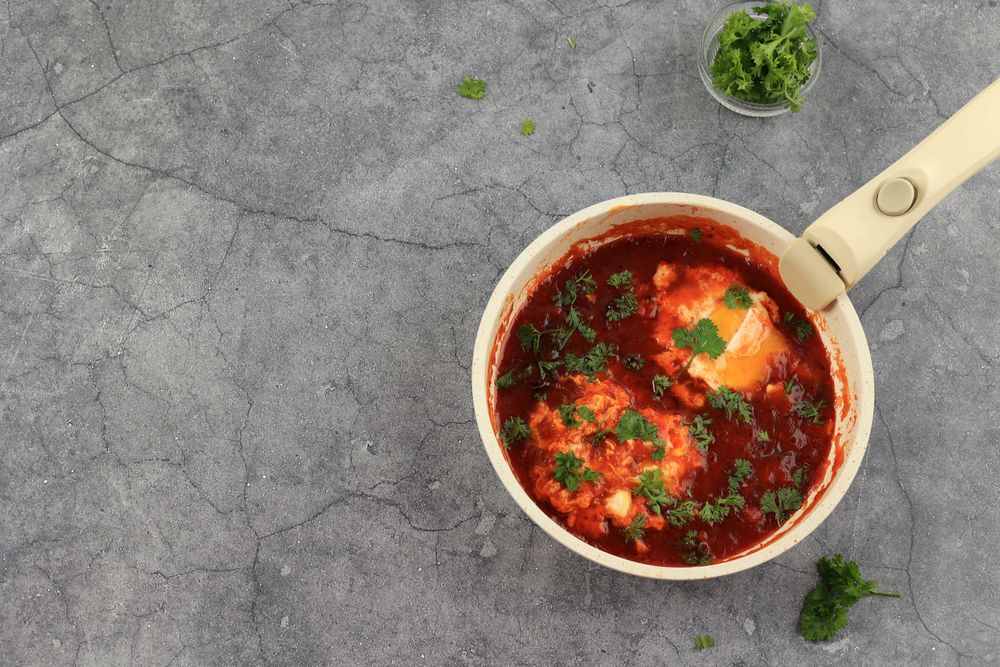 Shakshuka in a Frying Pan. Eggs Poached in Spicy Tomato Pepper Sauce.