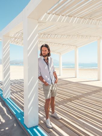 Relaxed man standing in gazebo on beach
