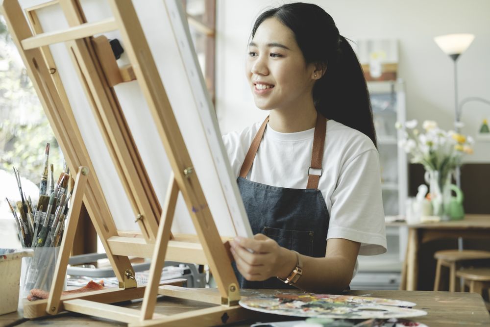 Crafting Inspiration. Female Artist Sketching and Painting in Workshop