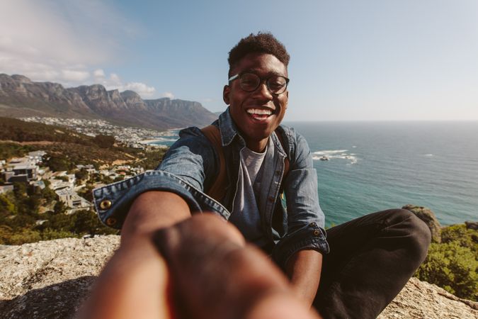 Black man on top of a mountain taking selfie