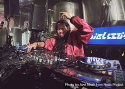 London, England, United Kingdom - Nov 9, 2022: Female DJ with hand up behind the decks 0yvqn5
