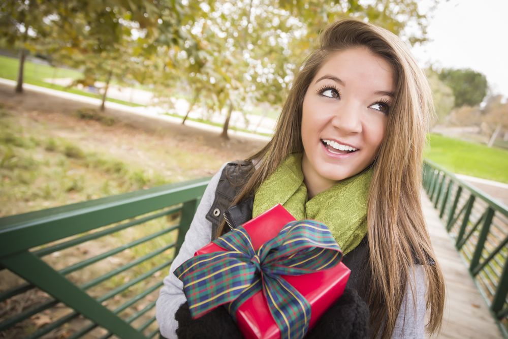 Woman with Wrapped Gift with Bow Outdoors