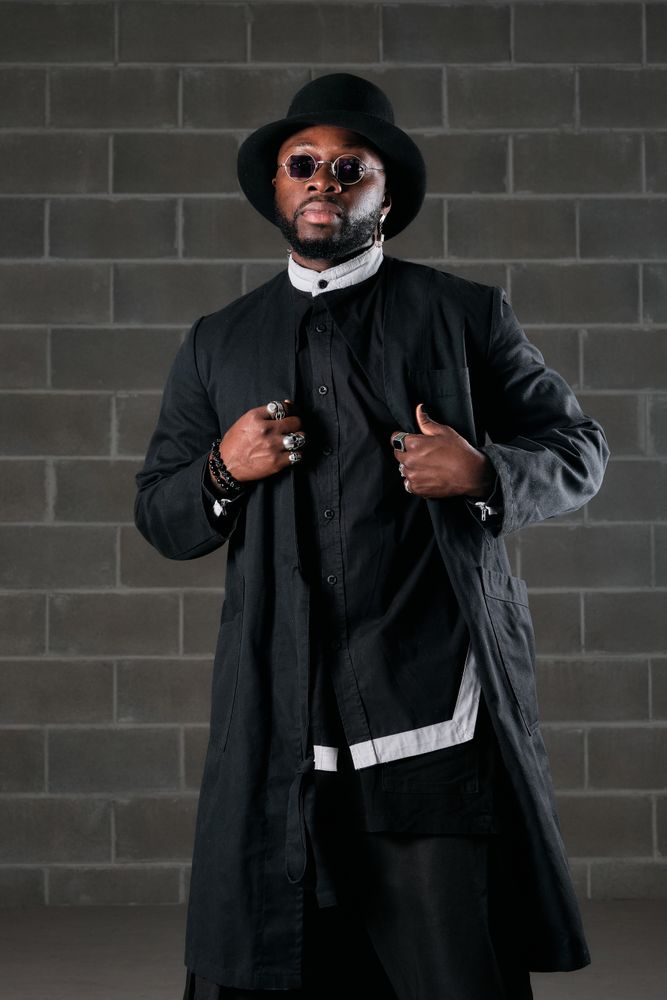Serious trendy man in black outfit and top hat