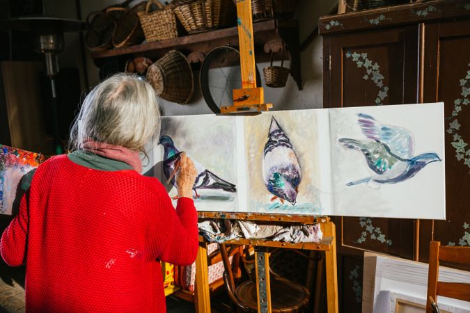 Anonymous woman painting on canvas in garden