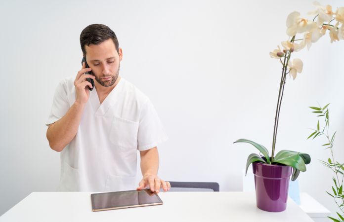 a physiotherapist attending to his patients by telephone