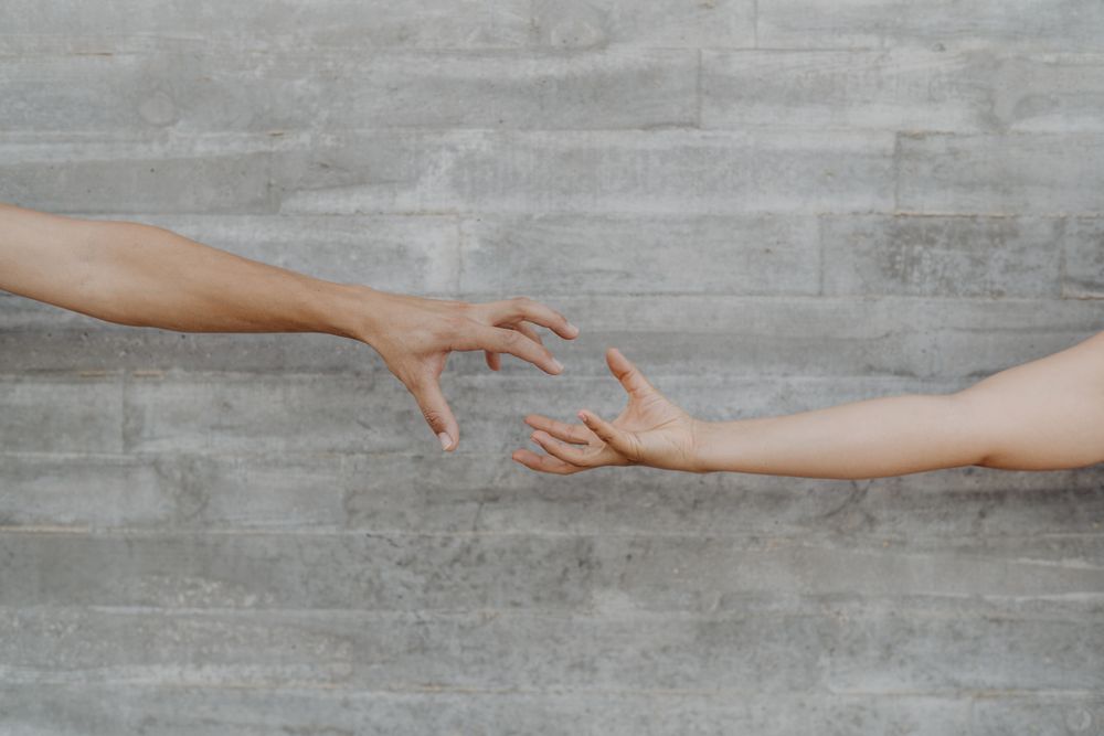 Hands with action of taking on background of grey wall