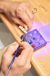 Anonymous dental technician painting denture