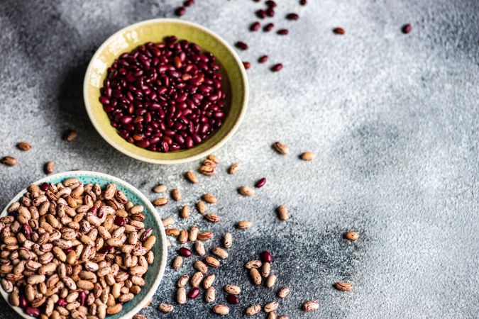 Bowls of dried legumes from pantry on grey counter with copy space