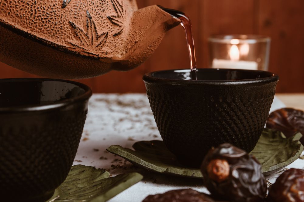 Aromatic tea dates and clay teapot on table