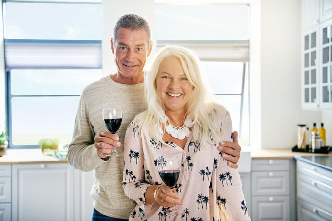 Portrait of smiling older couple holding red wine