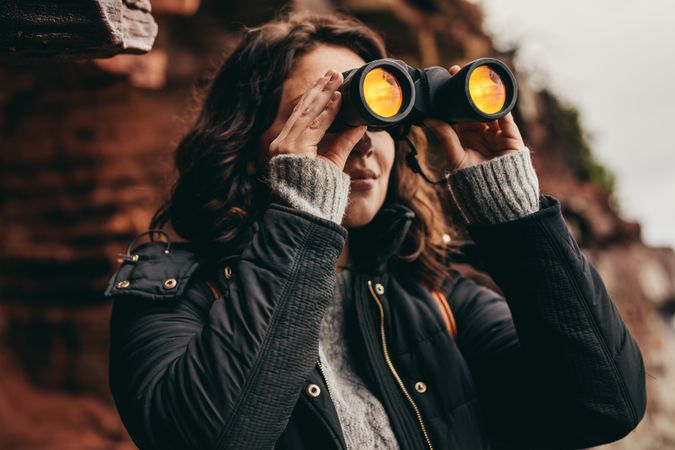 Woman traveler looking through binoculars