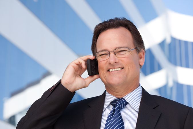 Businessman Smiles as He Talks on His Cell Phone