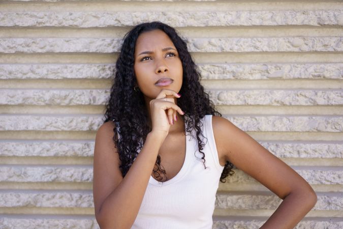 A Contemplative Young Woman Engaged in Deep Thought Set Against a Textured Background