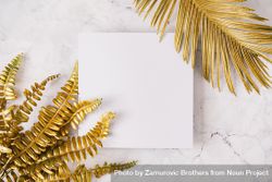 Gold leaves on corner of square paper on marble background 4d3Zn5