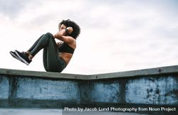 Female athlete doing fitness training on rooftop on a cloudy morning 4m3O70